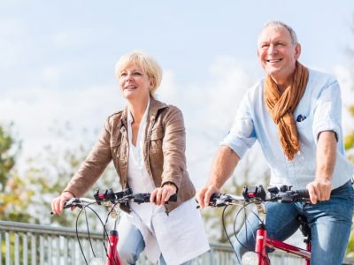 senior-couple-with-bicycles-bridge